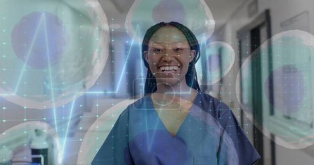 Bild von Zellen und Datenverarbeitung über afrikanisch-amerikanische Ärztin im Krankenhaus. Globale Medizin, Gesundheitswesen, Verbindungen, Computer- und Datenverarbeitungskonzept digital generiertes Bild.