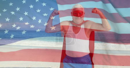 Téléchargez les photos : Image du drapeau des Etats-Unis sur l'homme super-héros caucasien sur la plage en été. Etats-Unis, patriotisme américain, drapeau national et concept de style de vie image générée numériquement. - en image libre de droit