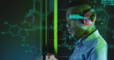 Bild der Datenverarbeitung über einen männlichen afrikanisch-amerikanischen Serverraumarbeiter mit Kopfhörern. Konzept für Cloud Computing Konzept digital generiertes Bild.