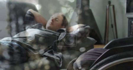 Photo for Image of light spots over disabled cuacasian man lying in bed. International day of persons with disabilities concept digitally generated image. - Royalty Free Image