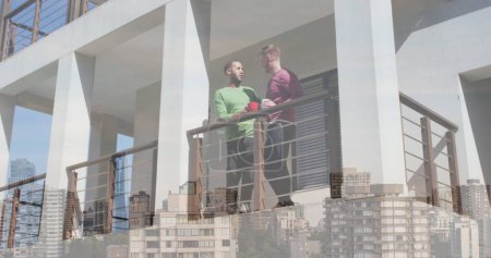 Téléchargez les photos : Image du paysage urbain sur divers couples masculins debout sur le balcon et boire du café. Saint Valentin, concept d'amour et de célébration image générée numériquement. - en image libre de droit