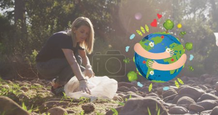 Téléchargez les photos : Image d'embrasser globe sur femme caucasienne heureuse ramassant des ordures dans la campagne. éco conservation bénévole mois image numérique. - en image libre de droit