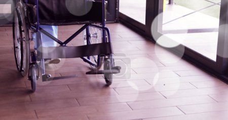 Image of spots over wheelchair. International day of persons with disabilities concept digitally generated image.