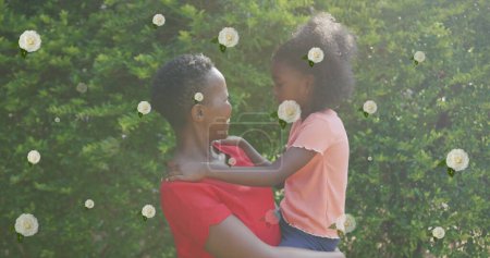 Photo for Image of roses over happy african american mother and daughter hugging in garden. family life, childhood, love and nature concept digitally generated image. - Royalty Free Image