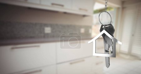 Foto de Imagen de llaves de casa plateadas y llavero en forma de casa colgando sobre una cocina de enfoque 4k - Imagen libre de derechos