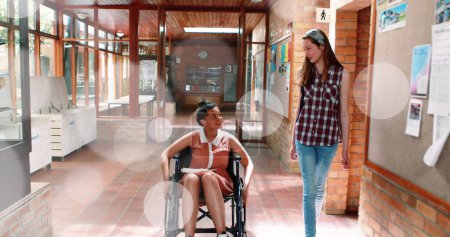 Image of light spots over disabled biracial student with friend. International day of persons with disabilities concept digitally generated image.