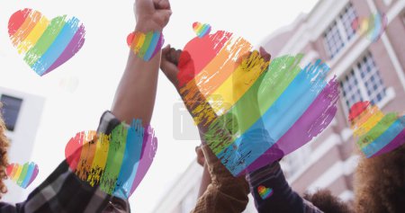 Bild von Regenbogenherzen über Händen diverser Demonstranten. lgbt Rechte und Gleichstellungskonzept digital generiertes Image.