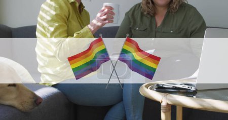 Foto de Imagen de banderas de arco iris sobre la sección media de una pareja lesbiana tomando café. lgbt Derechos y concepto de igualdad imagen generada digitalmente. - Imagen libre de derechos