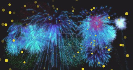 Photo for Image of yellow spots of light over blue new year fireworks exploding in night sky. New year, party, celebration and tradition concept digitally generated image. - Royalty Free Image