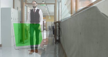Bild des Geschäftsmannes mit Laptop und grünem Bildschirm über Geschäftsmann, der im Büroflur geht. Geschäfts- und Kommunikationstechnologiekonzept digital generiertes Image.