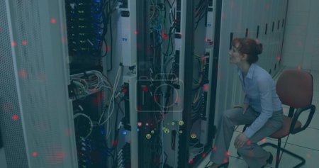 Image of media icons over caucasian female worker in server room. Global technology and digital interface concept digitally generated image.