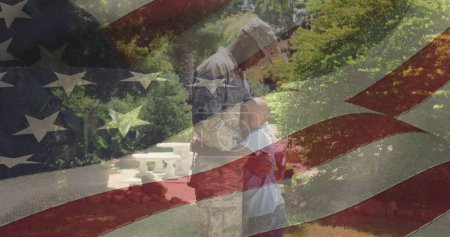 Téléchargez les photos : Image du drapeau des Etats-Unis agitant sur le père afro-américain embrassant son fils. patriotisme américain, indépendance et concept de célébration image générée numériquement. - en image libre de droit