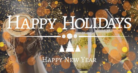 Image of happy holidays text in white over new year fireworks, champagne glasses and bottle. New year, greeting, party, celebration and tradition concept digitally generated image. 
