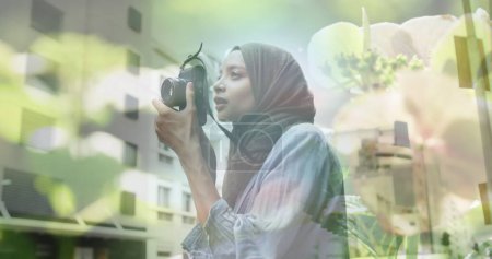 Téléchargez les photos : Image de femme asiatique en hijab avec caméra sur le paysage urbain. dehors et environ dans la ville, image générée numériquement. - en image libre de droit