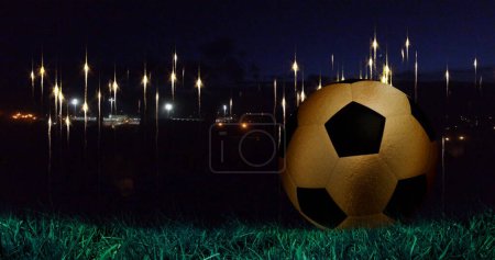 Image of glowing lights at nights sky over football ball. World cup soccer concept digitally generated image.