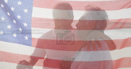 Photo for Image of flag of united states of america over senior biracial couple kissing on beach. American patriotism, diversity and tradition concept digitally generated image. - Royalty Free Image