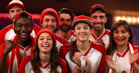 Photo for Front view of a group of fans wearing red and white jerseys cheering - Royalty Free Image