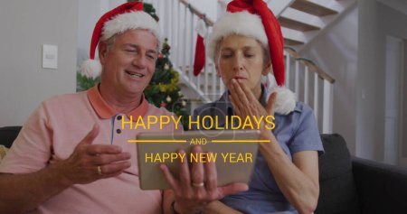 Image of happy holidays and happy new year text over senior caucasian couple wearing santa hats. Christmas, tradition and celebration concept digitally generated image.