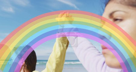Photo for Image of rainbow over woman holding hands over beach. female power, feminism and gender equality concept digitally generated image. - Royalty Free Image