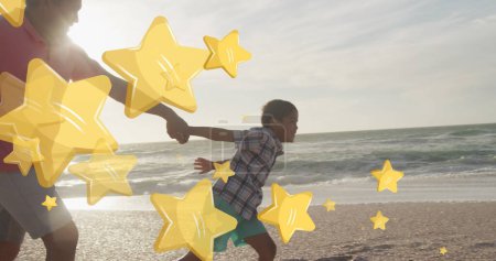 Photo for Image of stars over biracial man with grandson at beach. Christmas, celebration and digital interface concept digitally generated image. - Royalty Free Image