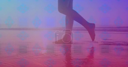 Téléchargez les photos : Modèle carré rose contre la section basse d'une femme marchant sur la plage. Concept d'amour et de relation - en image libre de droit