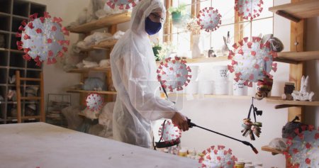 Bild von Viruszellen über dem kaukasischen Mann mit Mundschutz und desinfizierendem Schutzanzug. Hobby während covid 19 Pandemiekonzept digital generiertes Bild.