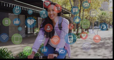 Image des icônes des médias sociaux et des données commerciales sur le cyclisme féminin biracial. Concept mondial de médias sociaux, d'affaires, de connexions et de traitement des données image générée numériquement.
