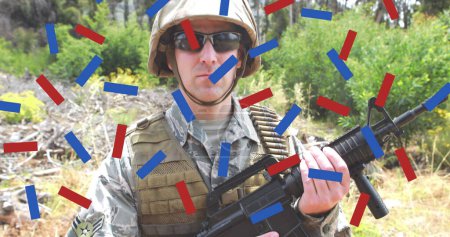 Téléchargez les photos : Composition des confettis rouges et bleus, sur soldat masculin dans la forêt tenant pistolet. patriotisme, indépendance, militaire et concept de célébration image générée numériquement. - en image libre de droit