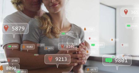 Image of social media icons on banners over caucasian couple in love embracing on balcony. social media, digital interface and connections concept digitally generated image.