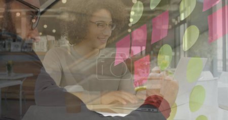 Téléchargez les photos : Image d'une femme souriante utilisant un ordinateur portable dans un café, au cours d'un remue-méninges d'hommes d'affaires écrivant des notes. concept d'entreprise et de technologie de communication image générée numériquement. - en image libre de droit