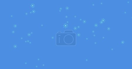 Foto de Imagen digital de múltiples iconos de copos de nieve que caen sobre fondo azul. fiesta de Navidad y concepto de celebración - Imagen libre de derechos