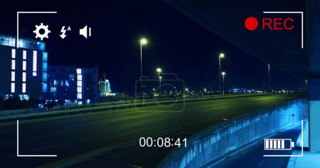 Téléchargez les photos : Image du trafic nocturne en mouvement rapide, vue sur un écran d'un appareil photo numérique en mode enregistrement avec icônes et minuterie 4k - en image libre de droit