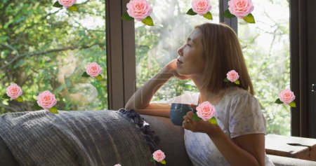 Téléchargez les photos : Image de roses roses sur une femme asiatique souriante buvant du café regardant par la fenêtre à la maison. concept détente, bonheur et bien-être image générée numériquement. - en image libre de droit