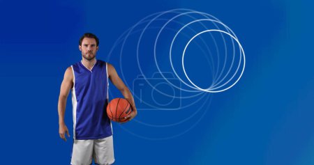 Foto de Imagen de círculos sobre el jugador de baloncesto masculino sosteniendo la pelota. concepto global de deportes, fitness y procesamiento de datos imagen generada digitalmente. - Imagen libre de derechos