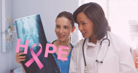 Foto de Imagen de cinta rosa de cáncer de mama sobre dos doctores sonrientes. imagen generada digitalmente del concepto de campaña de concienciación positiva del cáncer de mama. - Imagen libre de derechos
