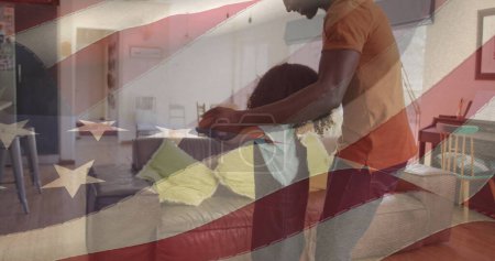 Bild der Flagge der USA, die über einem afrikanisch-amerikanischen Vater weht, der mit seiner Tochter tanzt. Amerikanischer Patriotismus, Unabhängigkeit und Feierkonzept digital generiertes Image.