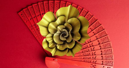 Bild von chinesischem Muster und Fächer mit Kopierraum auf rotem Hintergrund. Chinesisches Neujahr, Fest, Feier und Brauchtumskonzept digital generiertes Bild.