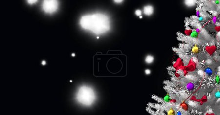 Foto de Árbol de Navidad sobre manchas blancas de luz flotando sobre fondo negro. fiesta de Navidad y concepto de celebración - Imagen libre de derechos