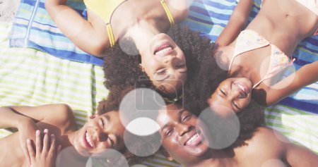 Photo for Image of light spots over happy african american family at beach. family holiday time and digital interface concept digitally generated image. - Royalty Free Image