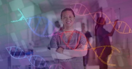 Image of dna strands over biracial female doctor in hospital. Global medicine, healthcare, connections, computing and data processing concept digitally generated image.
