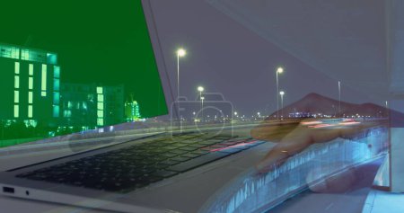 Image of hands of woman using laptop with green screen over sped up traffic in city at night. business and communication technology concept digitally generated image.