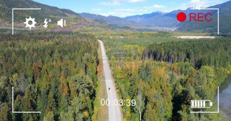 Imagen de la vista aérea del tráfico en una carretera rural, vista en una pantalla de una cámara digital en modo de grabación con iconos y temporizador 4k