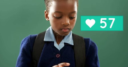 Foto de Acercamiento de un chico afroamericano deslizándose en su tableta con una barra de conteo de corazón al lado de su cabeza aumentando en número - Imagen libre de derechos
