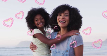 Téléchargez les photos : Image d'une heureuse mère et fille afro-américaine embrassant sur la plage au-dessus des cœurs. concept de loisirs, vacances et vie familiale image générée numériquement. - en image libre de droit