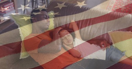 Téléchargez les photos : Image du drapeau des Etats-Unis agitant sur le père afro-américain couché sur le canapé avec sa fille endormie. patriotisme américain, indépendance et concept de célébration image générée numériquement. - en image libre de droit