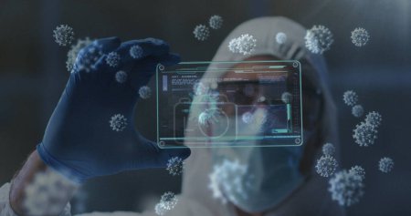 Covid-19 cells floating against health worker holding futuristic screen with medical data processing. covid-19 medical research and technology concept
