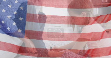 Téléchargez les photos : Image du drapeau des Etats-Unis agitant sur la fille caucasienne attachant des chaussures à son père. patriotisme américain, indépendance et concept de célébration image générée numériquement. - en image libre de droit