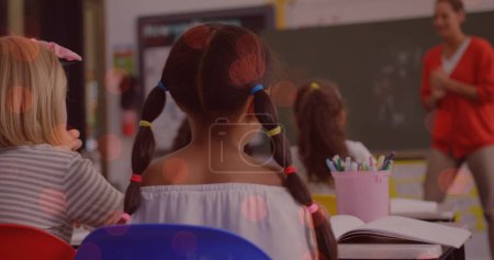 Téléchargez les photos : Image de taches de lumière sur une enseignante caucasienne souriante avec divers écoliers. Journée nationale des enseignants et concept de célébration image générée numériquement. - en image libre de droit