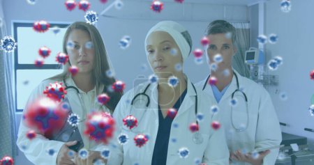 Image of a medical staff team in hospital with coronavirus cells floating on the foreground. Covid 19 pandemic health care science medicine concept digital composite