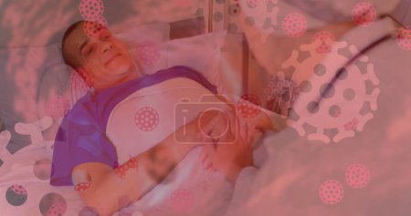 Foto de Imagen de un paciente hospitalizado con células coronavirus flotando en primer plano. Covid 19 pandemia salud ciencia medicina concepto digital compuesto - Imagen libre de derechos